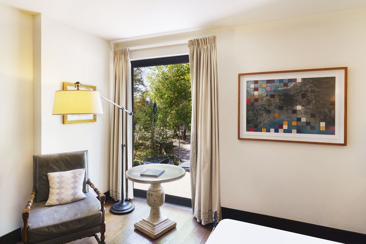 Cozy Urban room-double at Banyan Tree Puebla, chair by window, art on wall; calm, elegant setting.